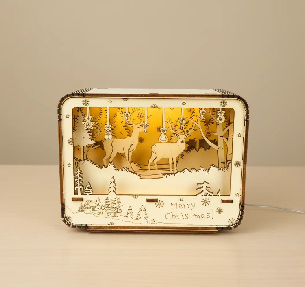 Front view of handcrafted 3D wooden LED Christmas light box featuring reindeer in a snowy forest design.