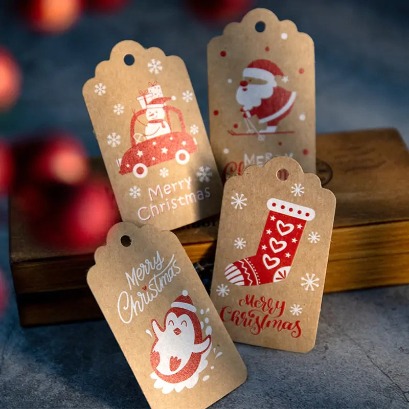 Velaflare holiday gift tags arranged on a wooden table with festive lights and Christmas wrapping accessories.