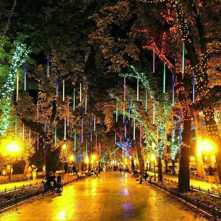 Velaflare LED meteor shower lights decorating trees along a city park pathway, creating a magical starlit walkway.